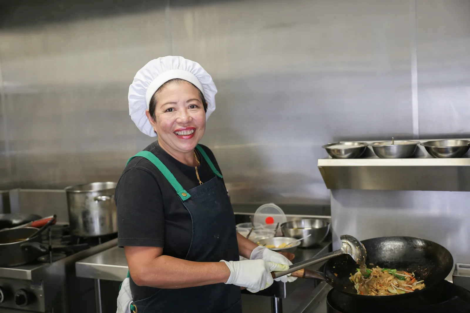 Smiling cook preparing food in a professional kitchen