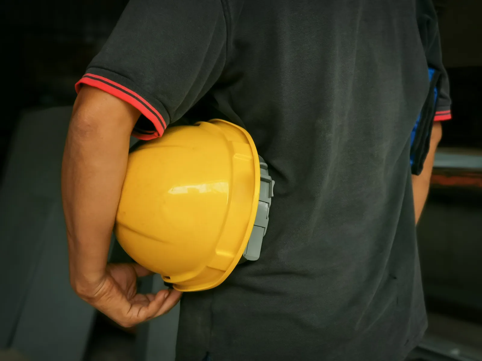 Construction worker holding a yellow safety helmet